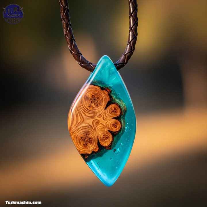 یک گردنبند آویز چوبی هنری، ترکیبی از چوب جوش و رزین فیروزه‌ای شفاف که به یک بند چرمی آویخته شده است. پس‌زمینه طبیعی با فوکوس ملایم، عکاسی ماکرو، با تأکید بر جزئیات ظریف ترکیب چوب و رزین، سبک عکاسی جواهرات.